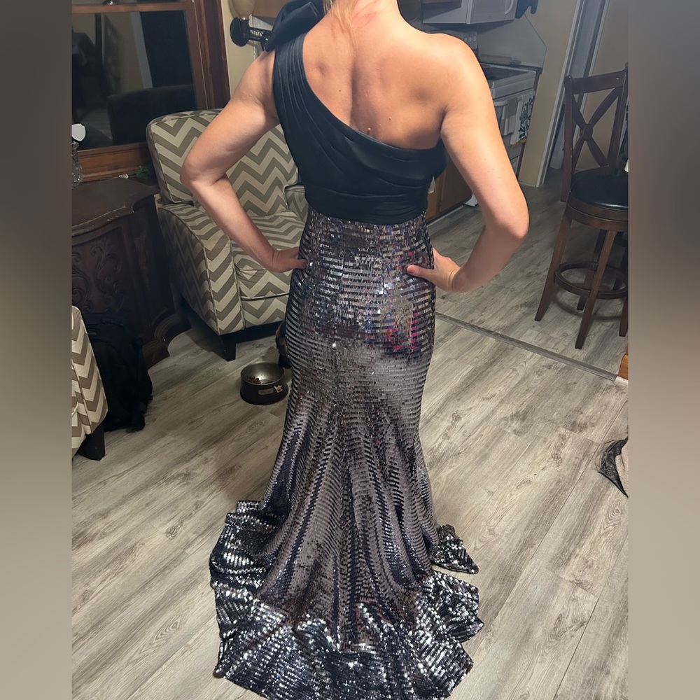 Black one shoulder sequin gown with train.